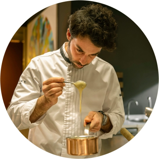 Javier Aranda preparando una salsa sobre una cazuela